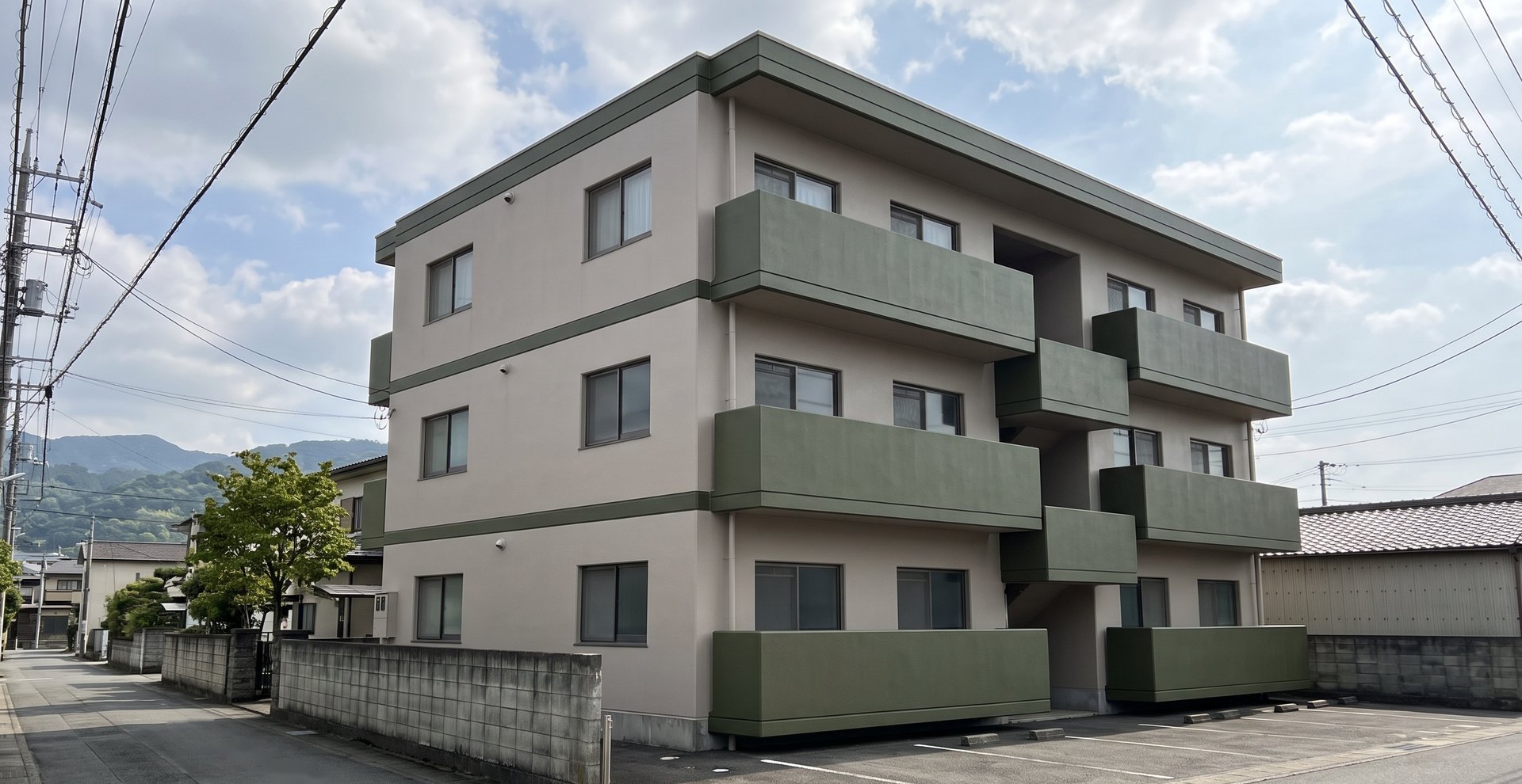 山を背にした住宅地で、塗り替えを終えた3階建てのマンション（イメージ）